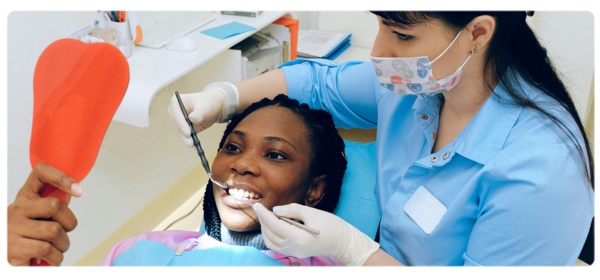 Hygienist performs examination on smiling patient